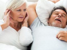 Senior man snoring and woman covering ears