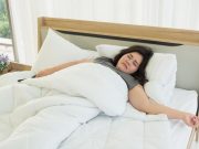 An Asian woman is sleeping in a comfortable bed.
