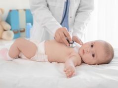 Doctor examining little baby with stethoscope in clinic. Baby health concept